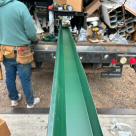 worker fabricating a metal gutter