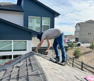 Roofer performing an inspection for asphalt shingle repair and maintenance