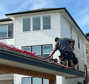 Roofer repairing shingles on an outdoor pavilion roof