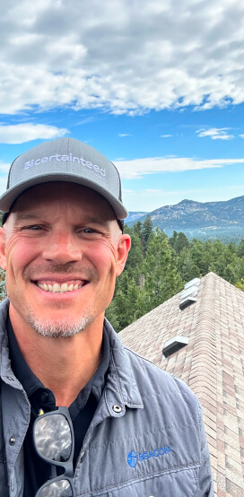 Scott Mainzer, roofing contractor, standing on a Colorado residential roof