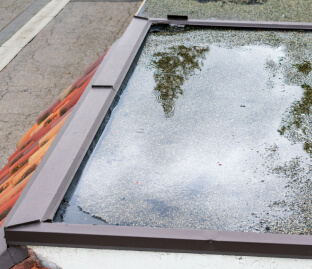 Large puddle of standing water on a low-slope flat roof