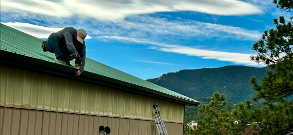 worker on the roof repairing its gutter