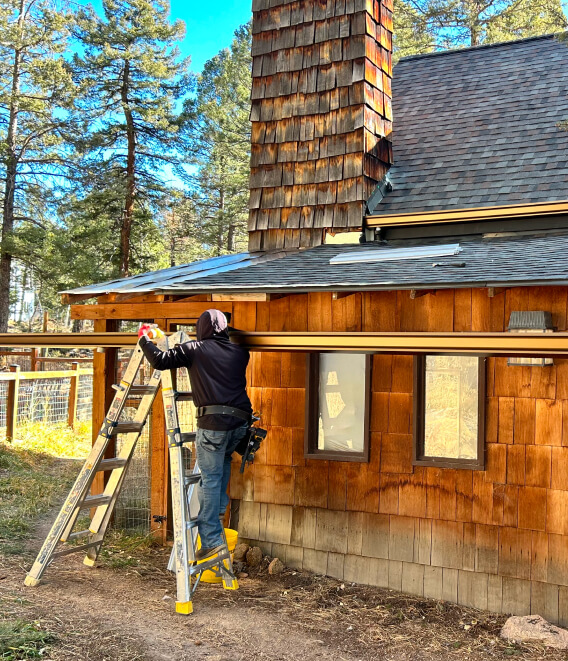roofer climbing a metal stair during gutter installation