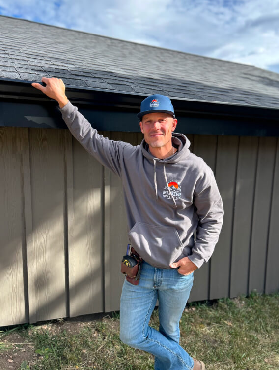 Colorado roofing contractor posing next to a low-slope roof